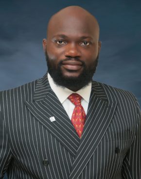 Bald headed and bearded African man in striped suit and orange tie