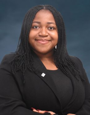 Smiling chubby light-skinned African woman in braids and a black jacket