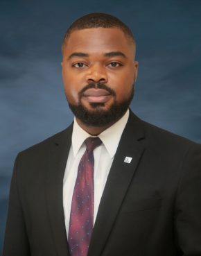 Bearded African man in a dark suit and a blue striped tie