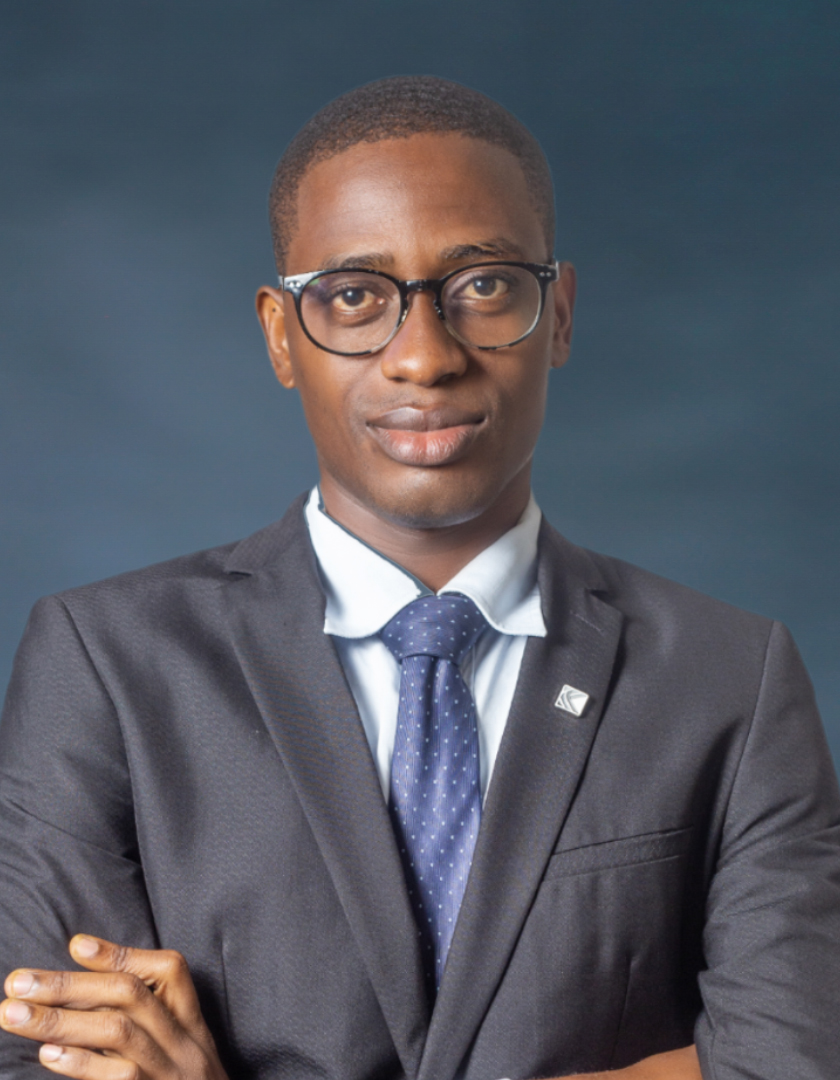 African man in a black suit and white, sporting a blue tie