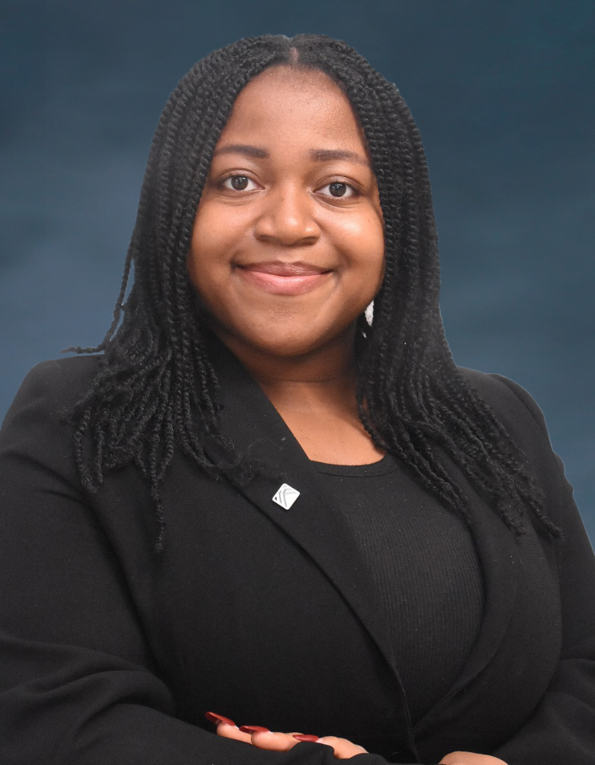 Smiling chubby light-skinned African woman in braids and a black jacket